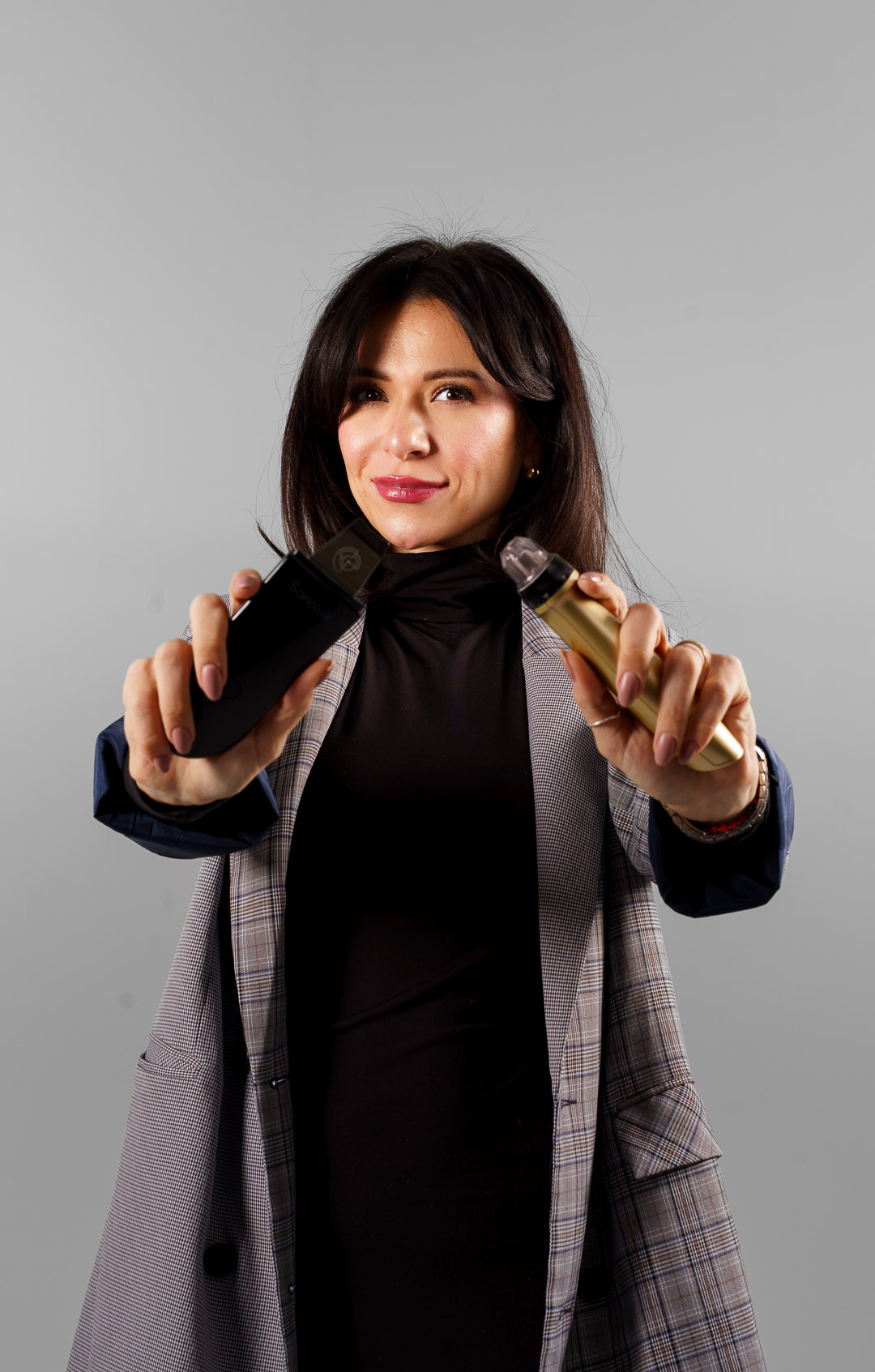 Esthetician holding professional skincare devices used in deep cleansing facials for congested skin