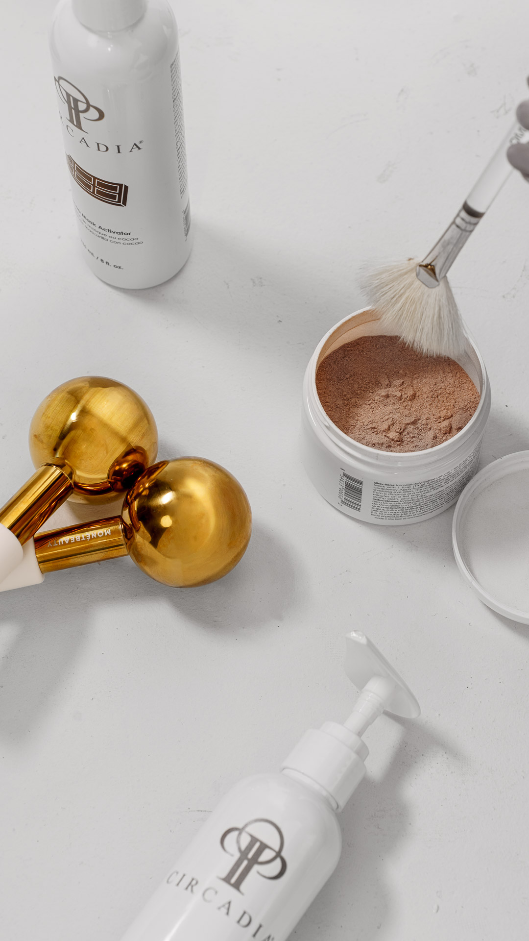 Gold facial rollers and skincare products laid out for a facial treatment